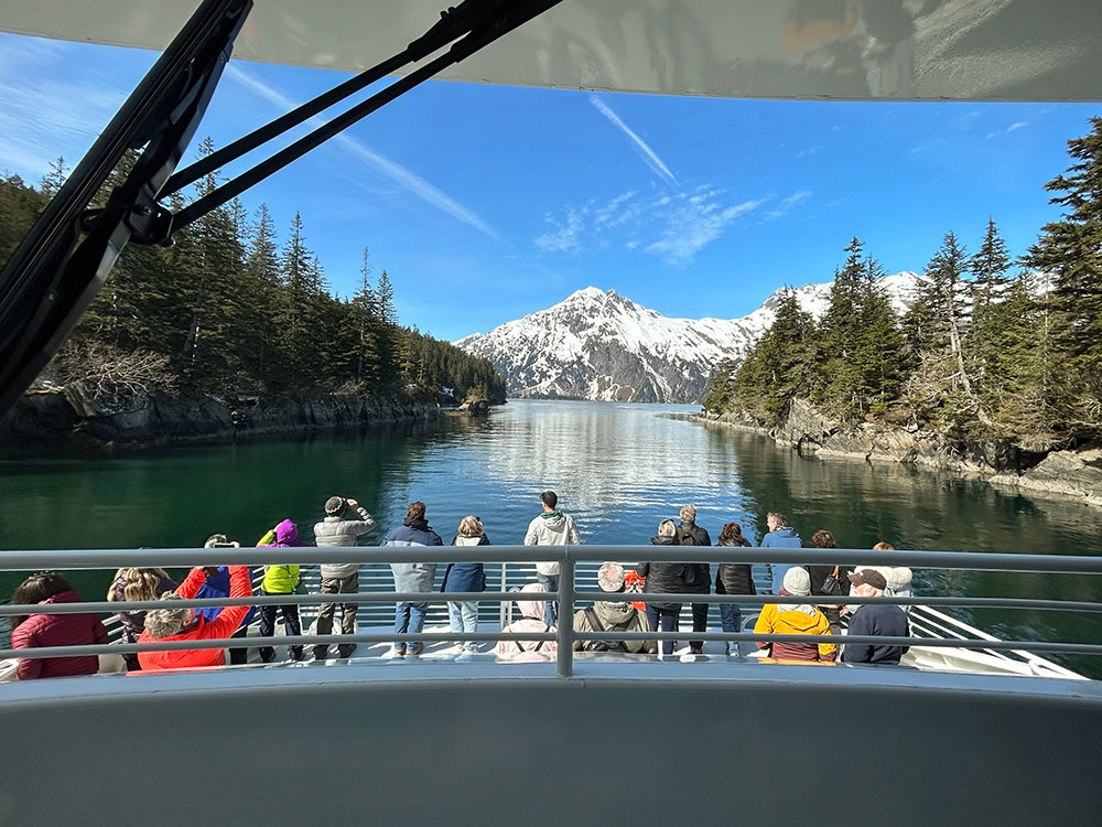 Group on the boat taking photos and looking at the scenery